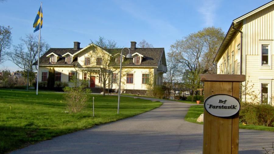 Bilden visar Herrgården där också en av flyglana skymtar. Den gula byggnaden till vänster är ett particierhus på andra sidan gatan, ett av tre lika utformade hus.