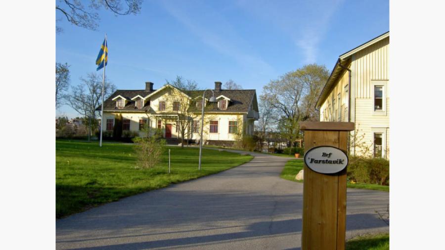 Bilden visar Herrgården där också en av flyglana skymtar. Den gula byggnaden till vänster är ett particierhus på andra sidan gatan, ett av tre lika utformade hus.